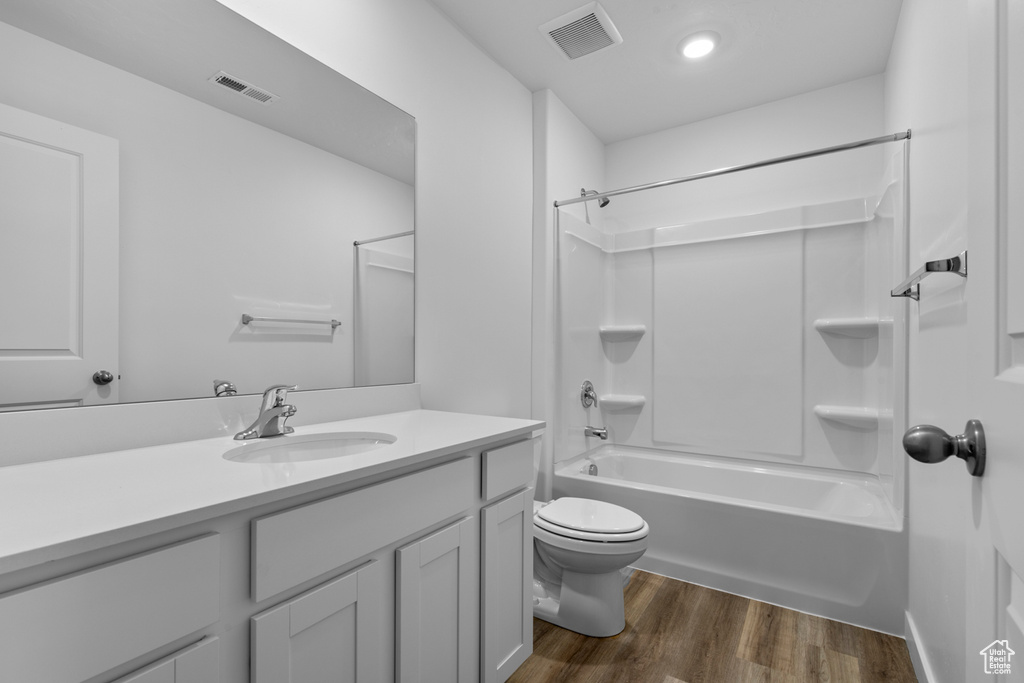 Full bathroom featuring shower / bathing tub combination, toilet, vanity, and hardwood / wood-style flooring