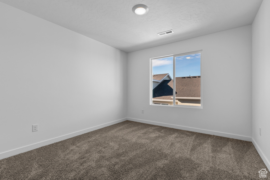 Unfurnished room featuring dark carpet