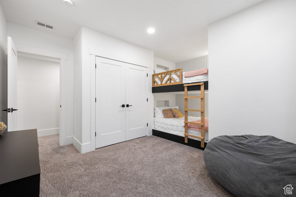 Bedroom with a closet and dark carpet