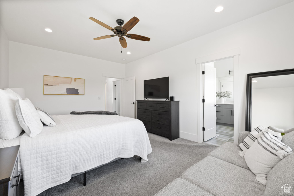 Bedroom featuring light carpet, ensuite bath, and ceiling fan