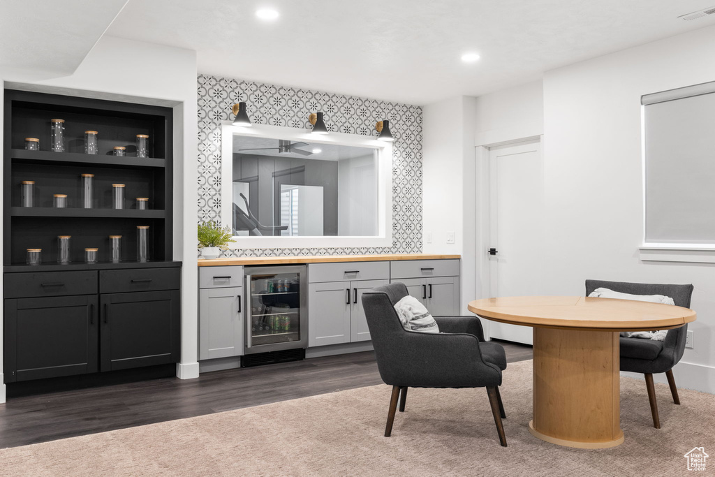 Bar featuring wine cooler, white cabinetry, and dark hardwood / wood-style flooring