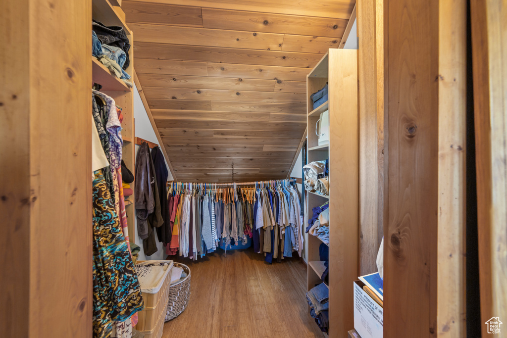Spacious closet featuring dark hardwood / wood-style flooring and vaulted ceiling