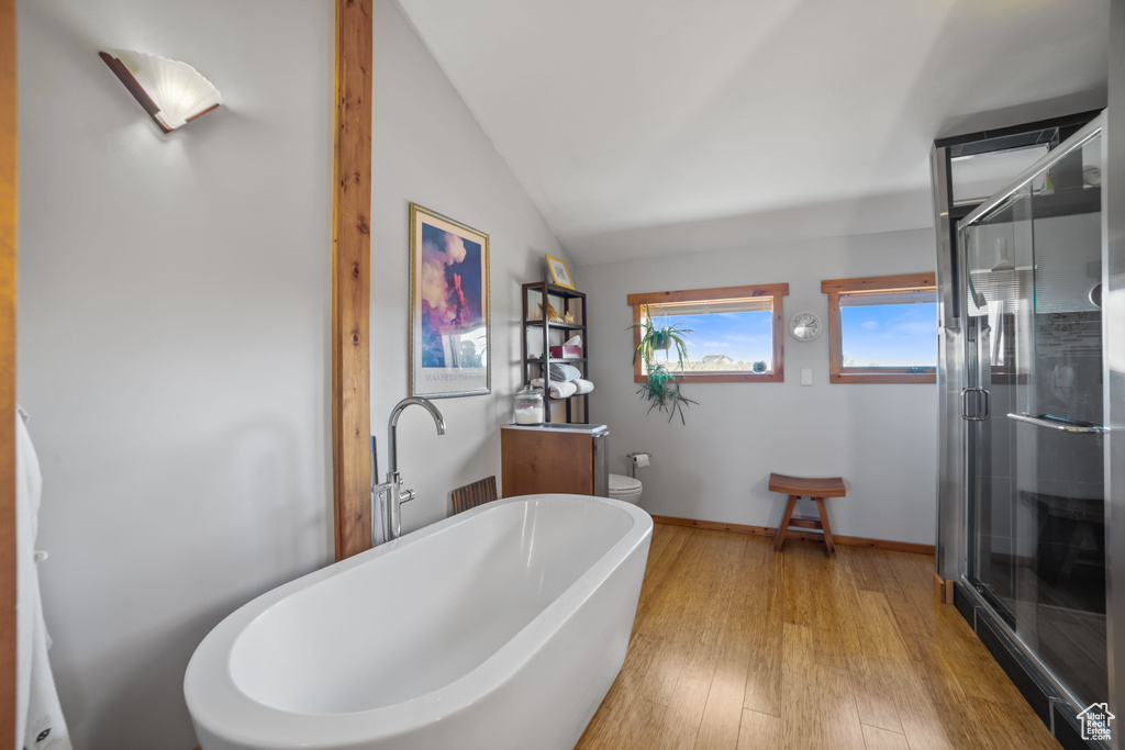 Bathroom with separate shower and tub, lofted ceiling, and hardwood / wood-style flooring