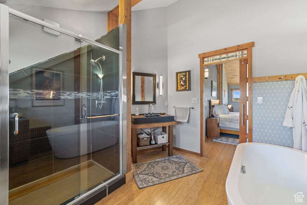 Bathroom featuring separate shower and tub, hardwood / wood-style floors, and vanity