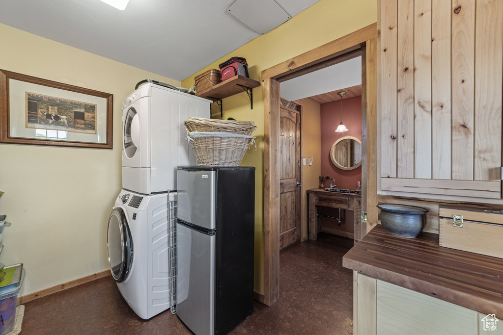 Laundry area with stacked washer and clothes dryer