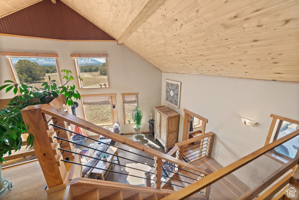 Stairway featuring wood ceiling, vaulted ceiling, and light hardwood / wood-style flooring