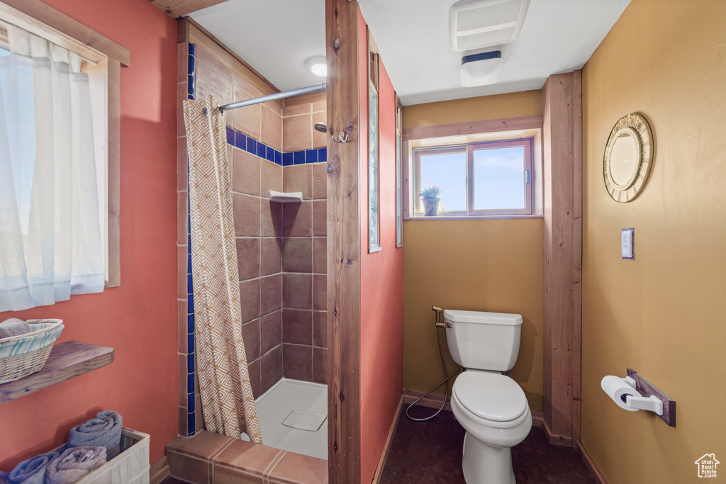 Bathroom with toilet and curtained shower