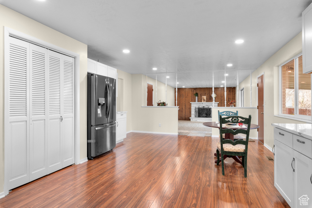 Kitchen featuring hardwood / wood-style floors, white cabinetry, and stainless steel fridge