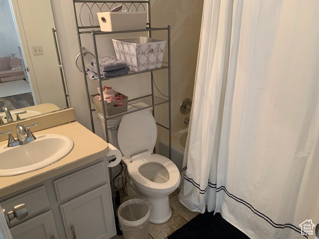 Full bathroom with shower / tub combo, vanity, tile floors, and toilet