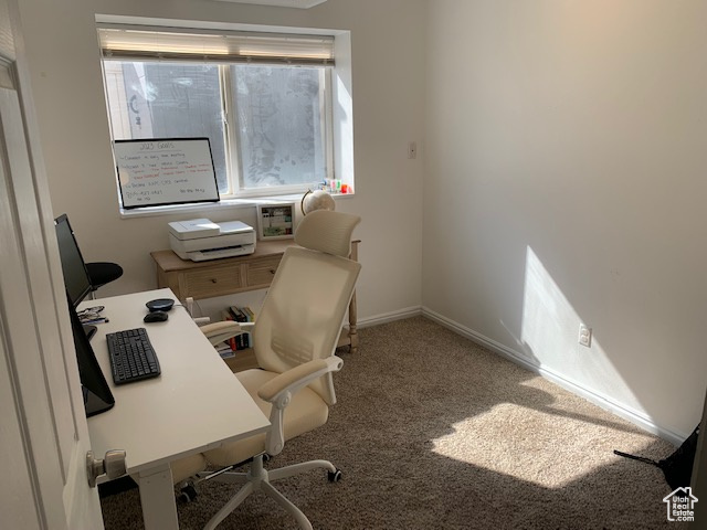 Home office featuring dark colored carpet