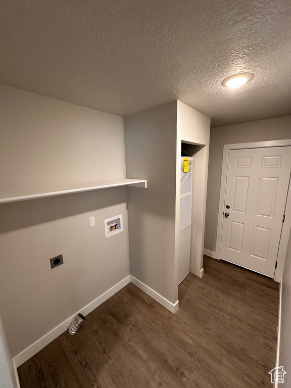 Clothes washing area with electric dryer hookup, washer hookup, a textured ceiling, and dark hardwood / wood-style flooring