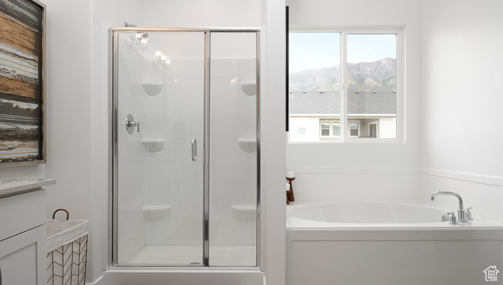 Bathroom featuring plus walk in shower, a mountain view, and a wealth of natural light