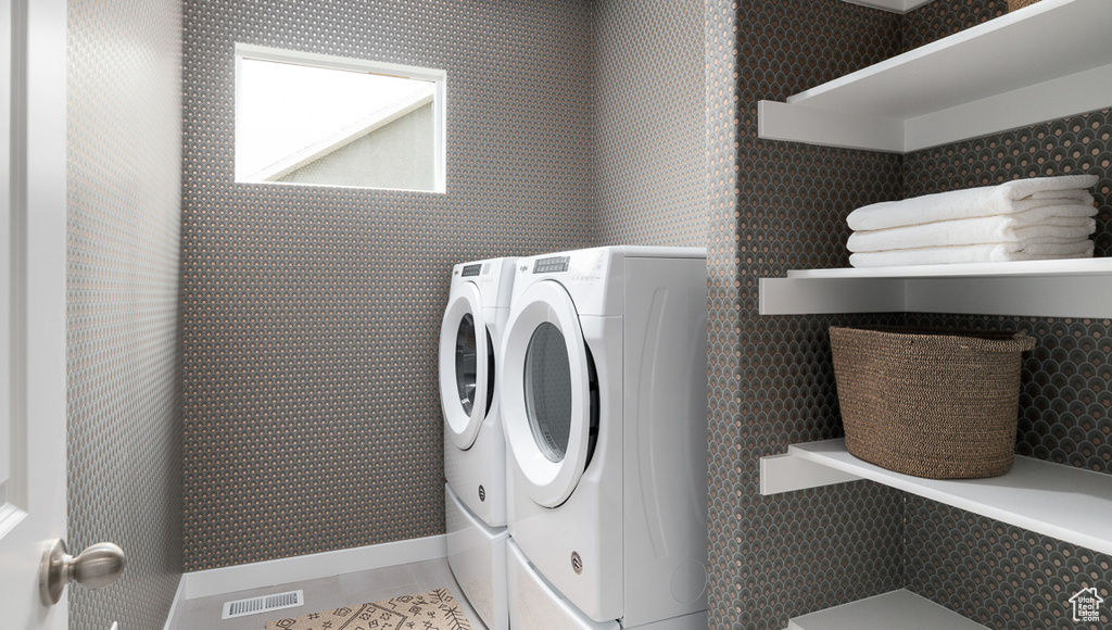 Washroom featuring washer and dryer and light tile flooring
