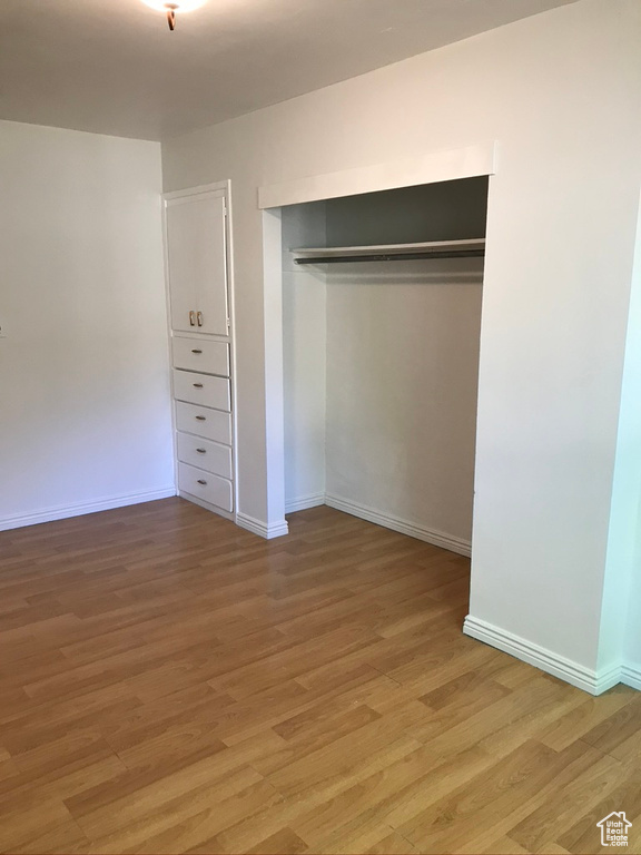 Unfurnished bedroom with hardwood / wood-style floors and a closet
