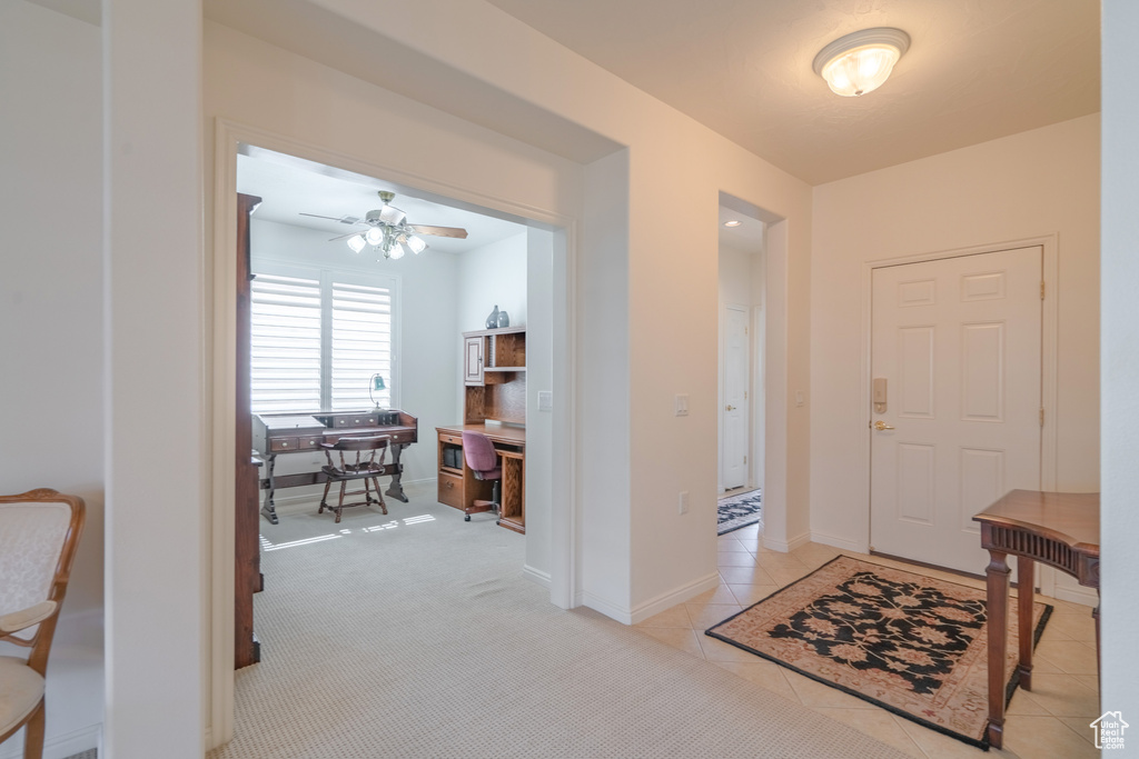 Foyer entrance featuring light tile floors and ceiling fan