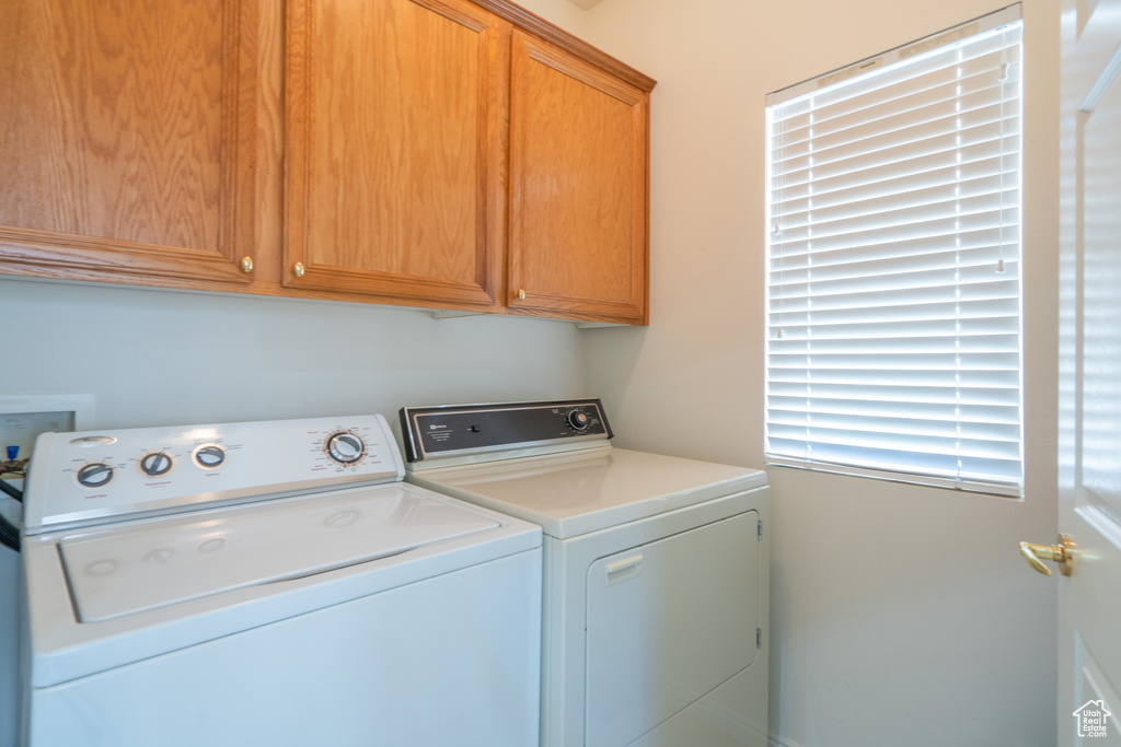 Laundry room featuring washer hookup, cabinets, and washer and dryer