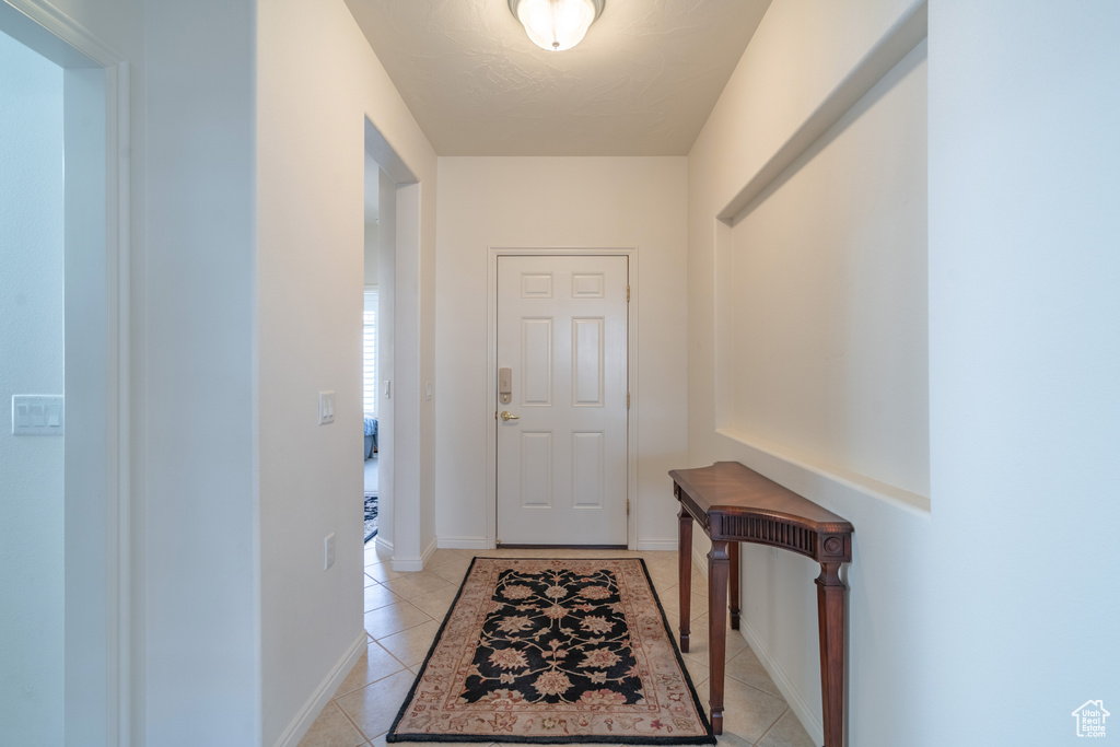 Doorway featuring light tile floors