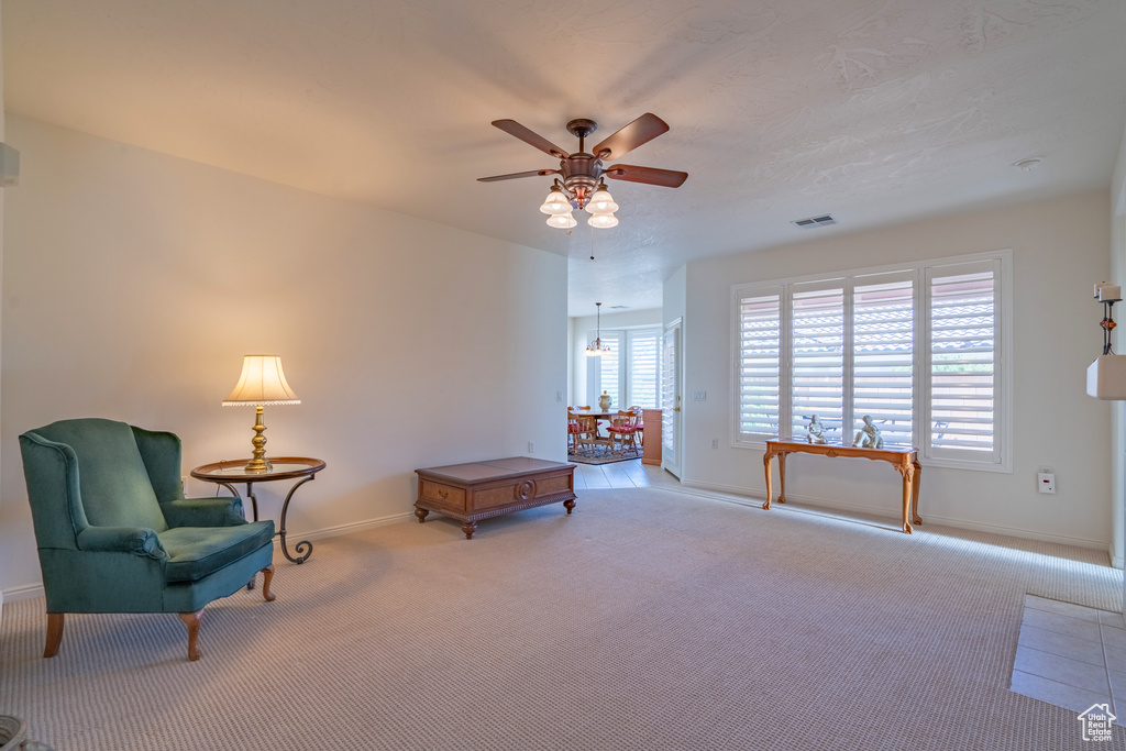 Sitting room with light colored carpet and ceiling fan