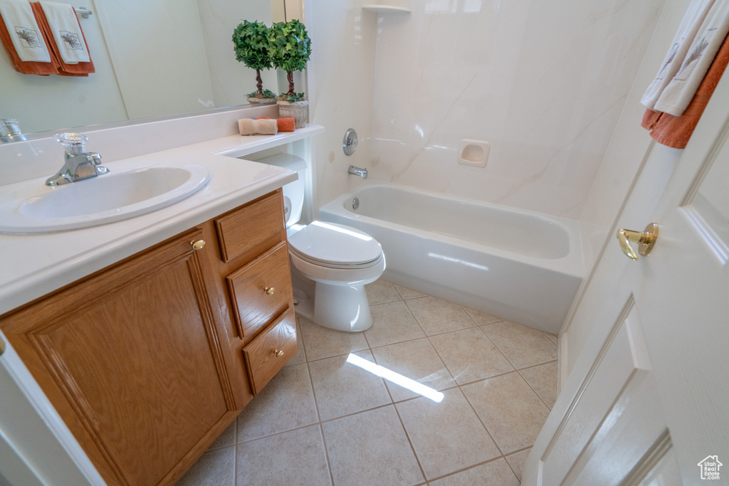 Full bathroom with tub / shower combination, toilet, large vanity, and tile flooring