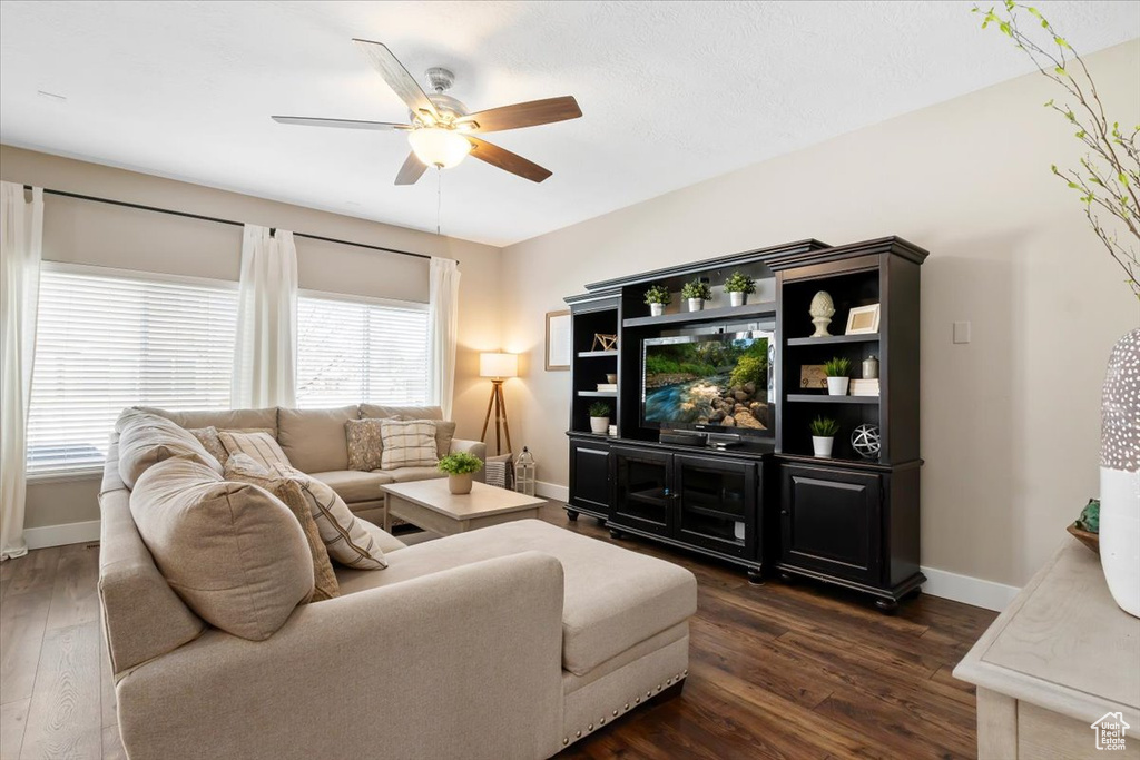 Living room with dark hardwood / wood-style floors and ceiling fan