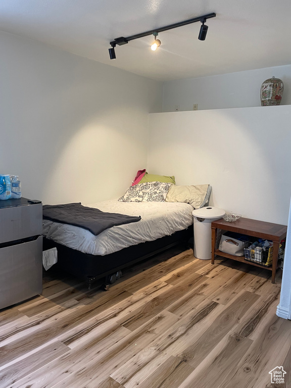 Bedroom featuring hardwood / wood-style flooring and track lighting