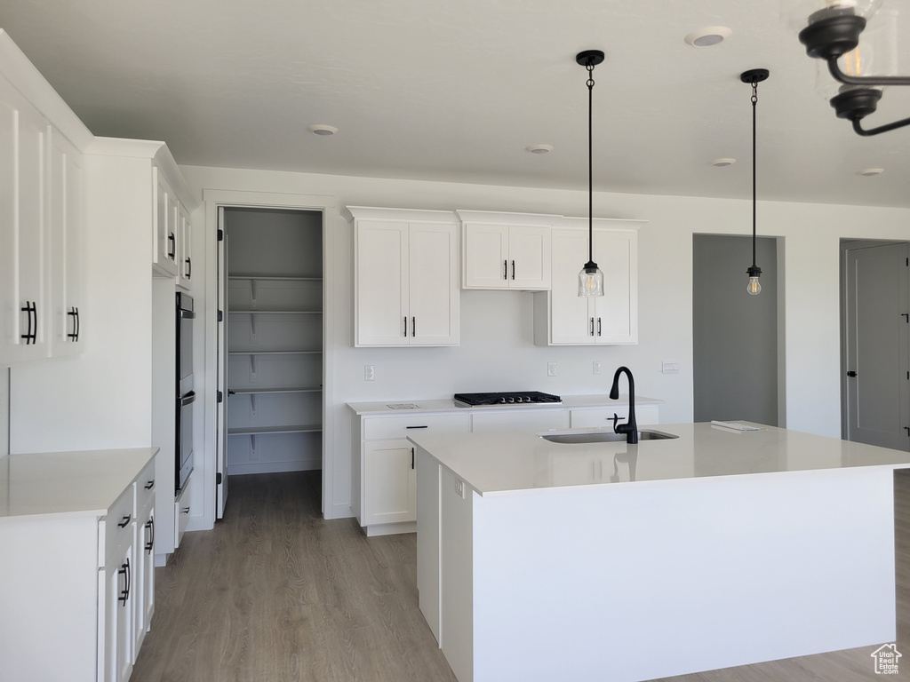 Kitchen with white cabinets, sink, and pendant lighting