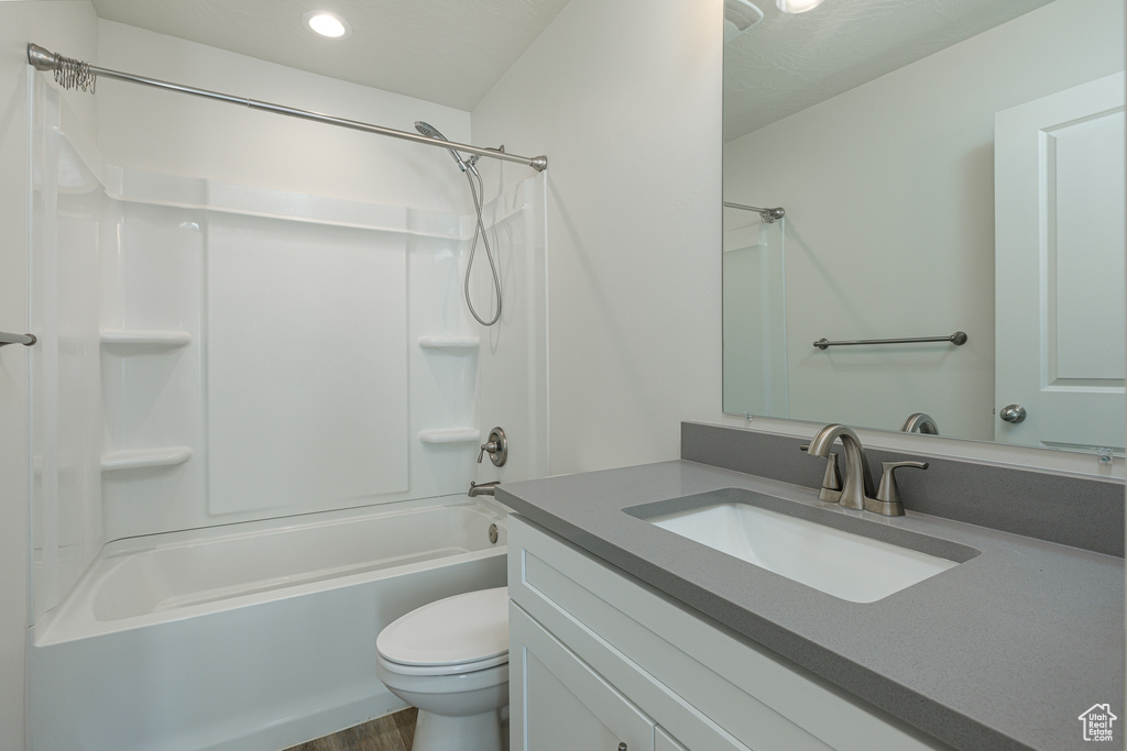 Full bathroom featuring vanity, wood-type flooring, toilet, and bathing tub / shower combination