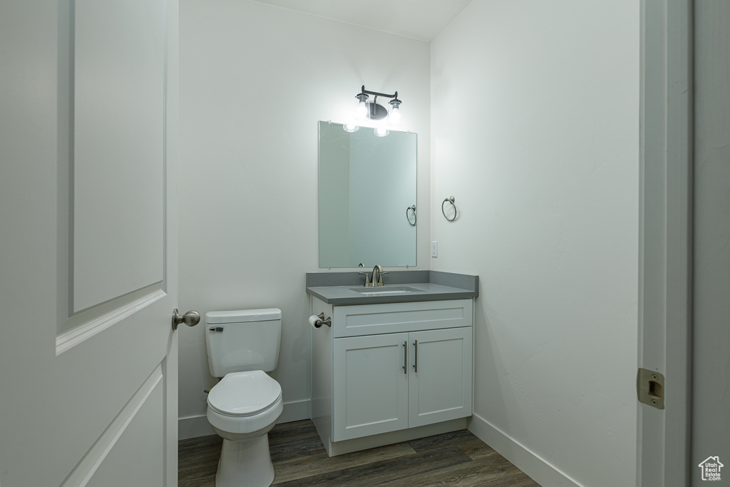 Bathroom featuring toilet, hardwood / wood-style floors, and oversized vanity