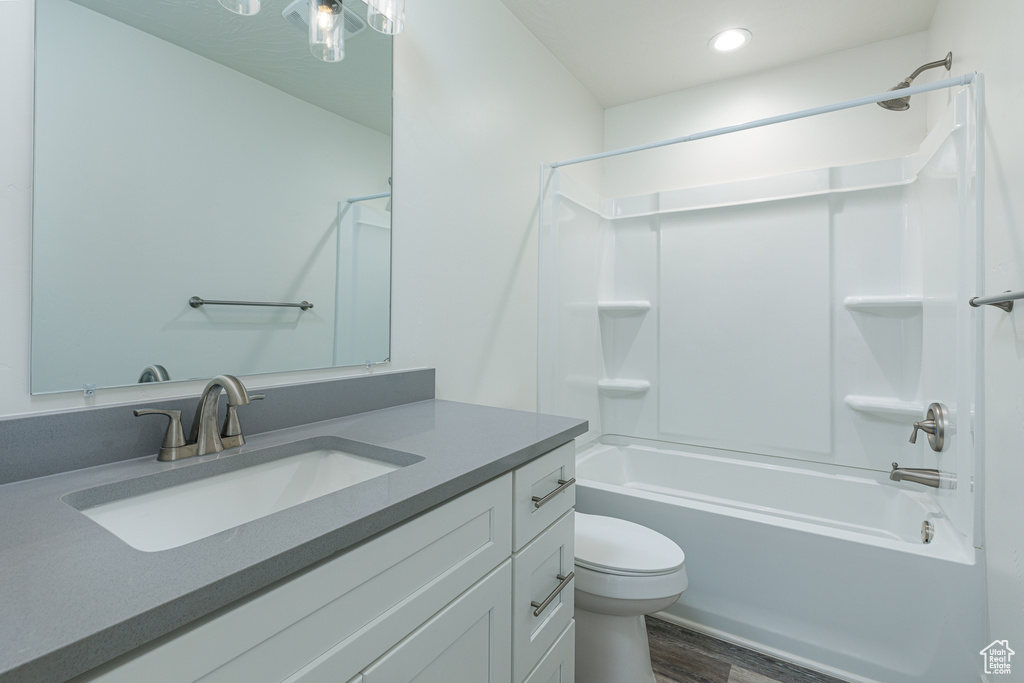 Full bathroom featuring shower / bathtub combination, toilet, wood-type flooring, and vanity