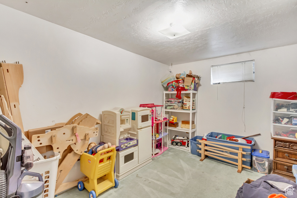 Playroom with light carpet and a textured ceiling