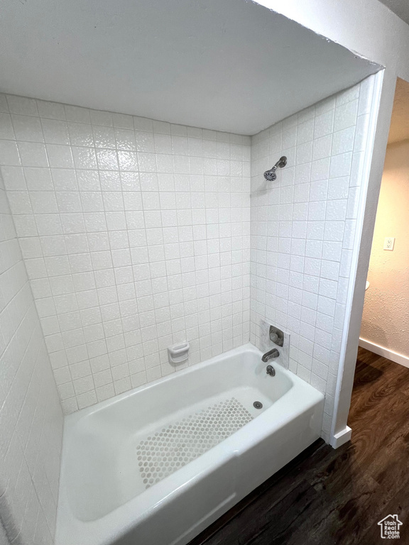 Bathroom with wood-type flooring and tiled shower / bath