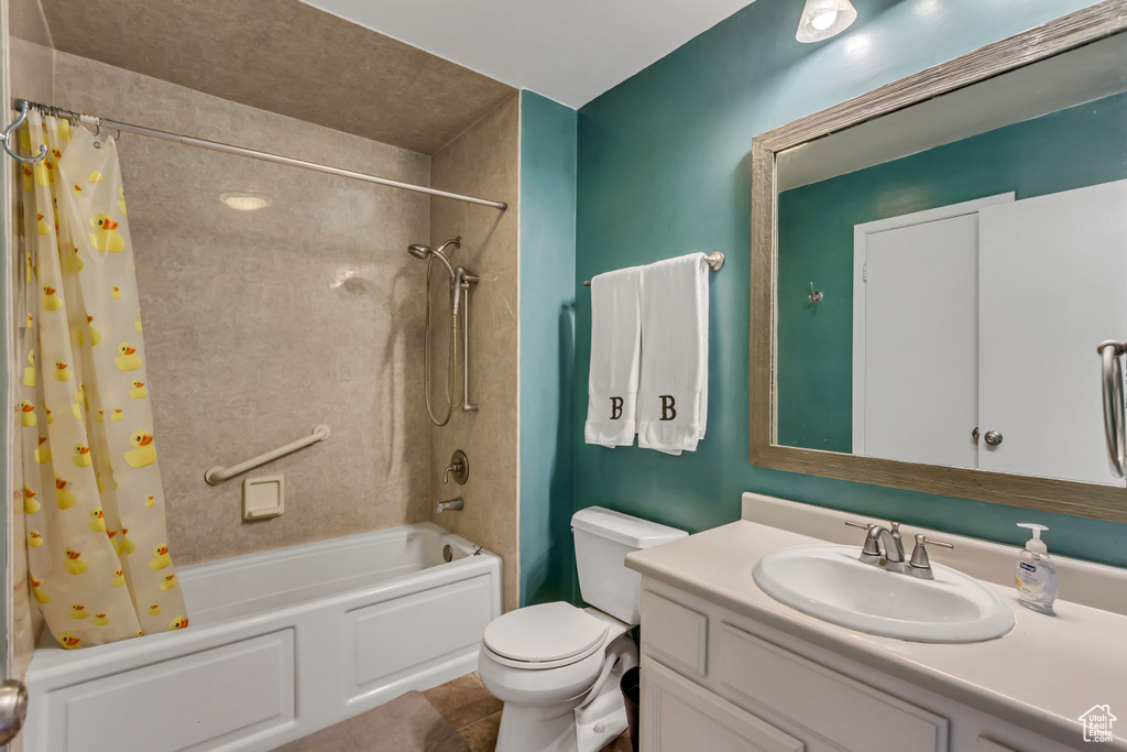 Full bathroom with toilet, shower / bath combo, tile floors, and vanity