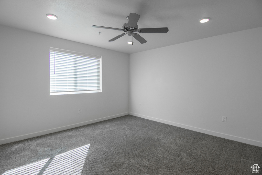 Carpeted empty room with ceiling fan