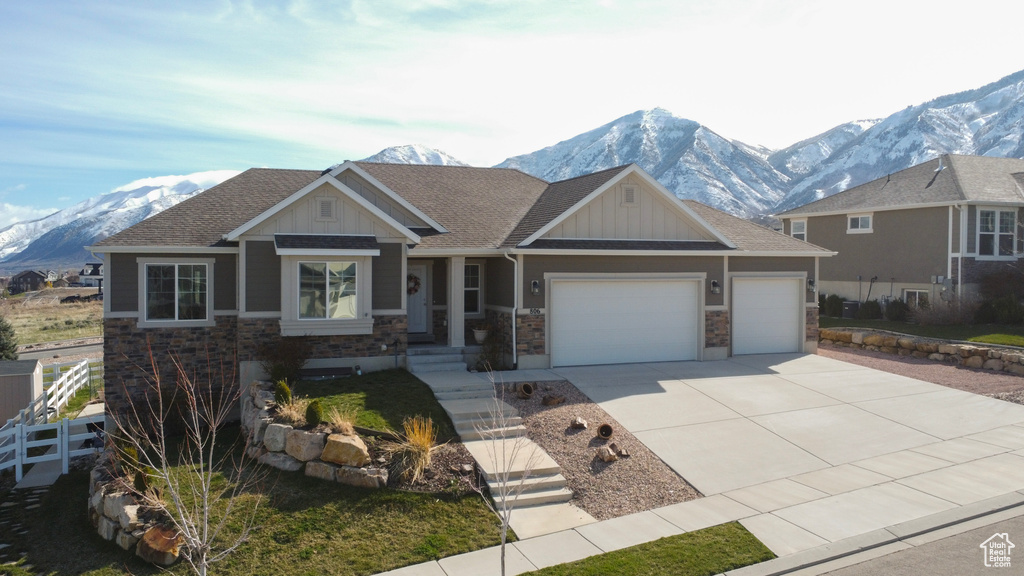 View of front of property with a mountain view and a garage