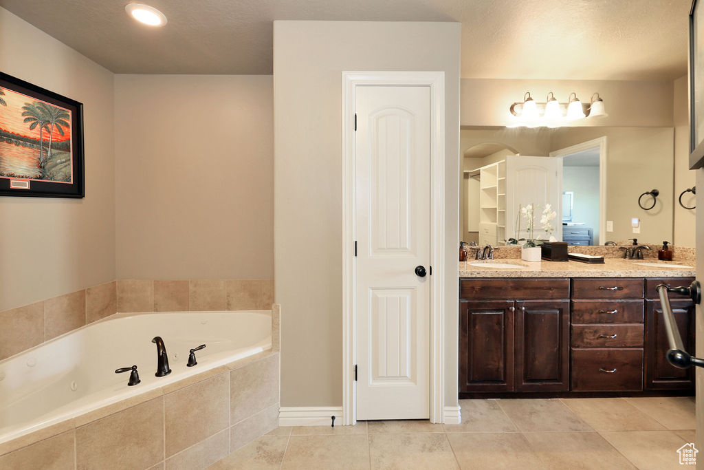 Bathroom featuring tile flooring, dual sinks, and large vanity
