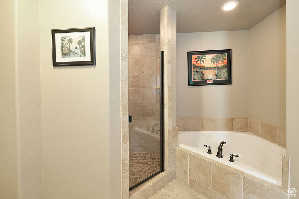Bathroom featuring separate shower and tub and a textured ceiling
