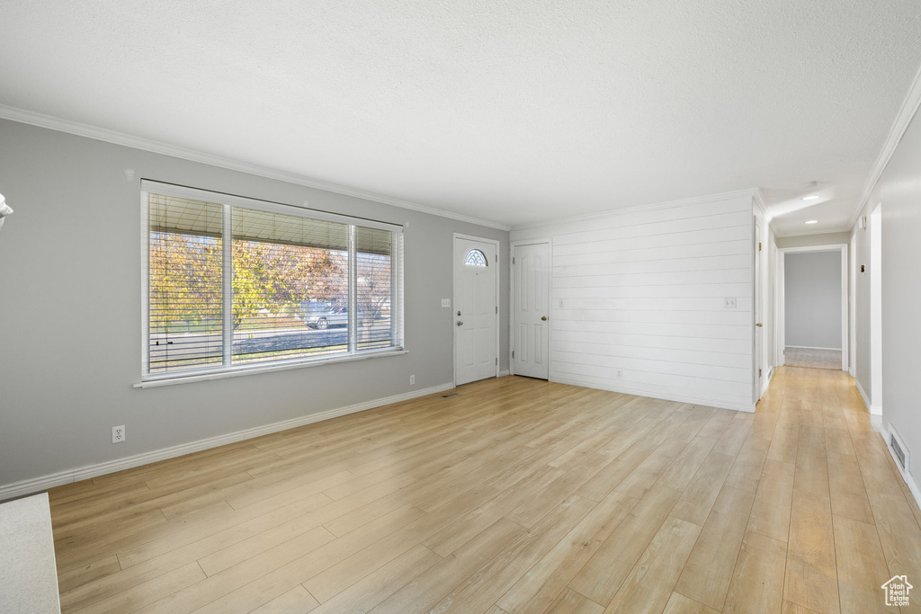 Unfurnished room with crown molding and light hardwood / wood-style flooring