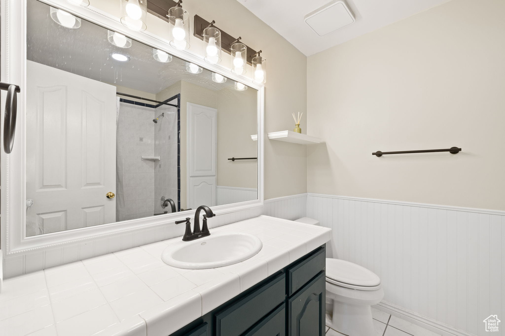 Bathroom featuring vanity, tile flooring, and toilet