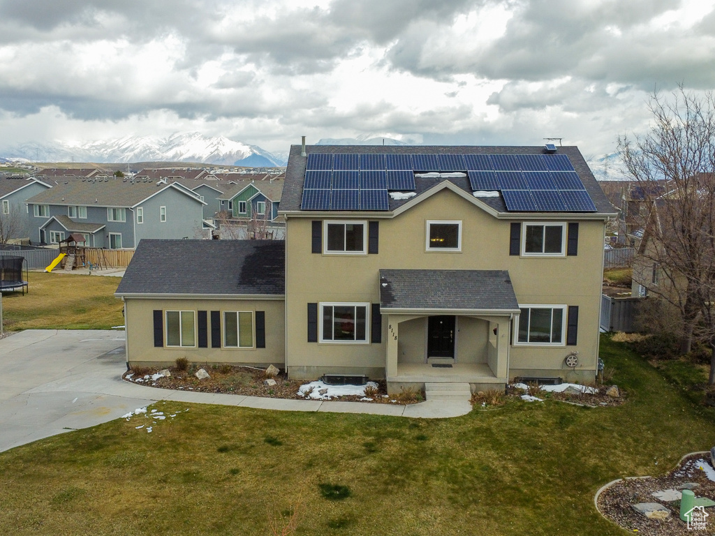 View of front of house featuring a front yard, a playground, and solar panels