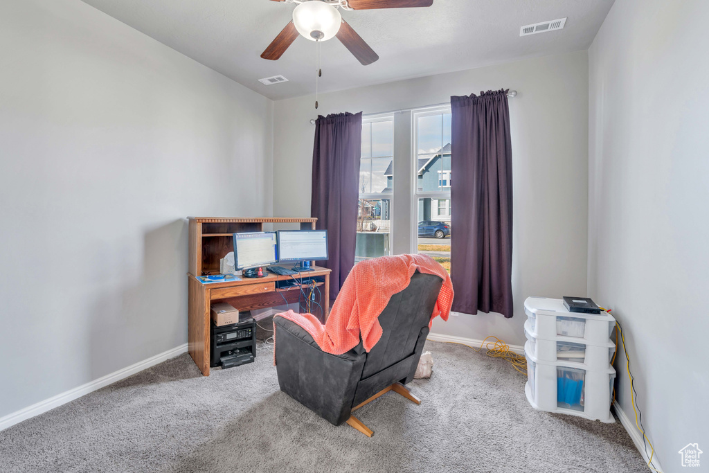 Carpeted home office featuring ceiling fan