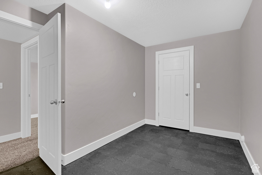 Unfurnished room with dark tile flooring