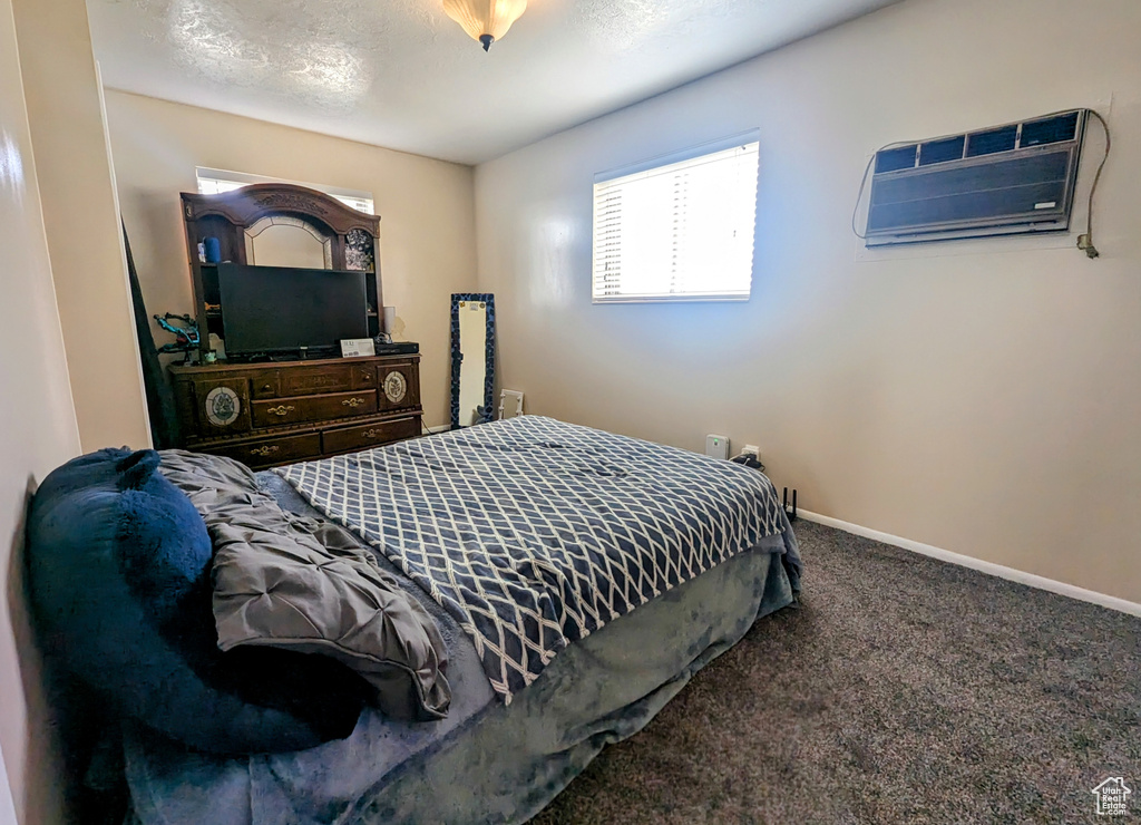 Carpeted bedroom with a wall mounted air conditioner