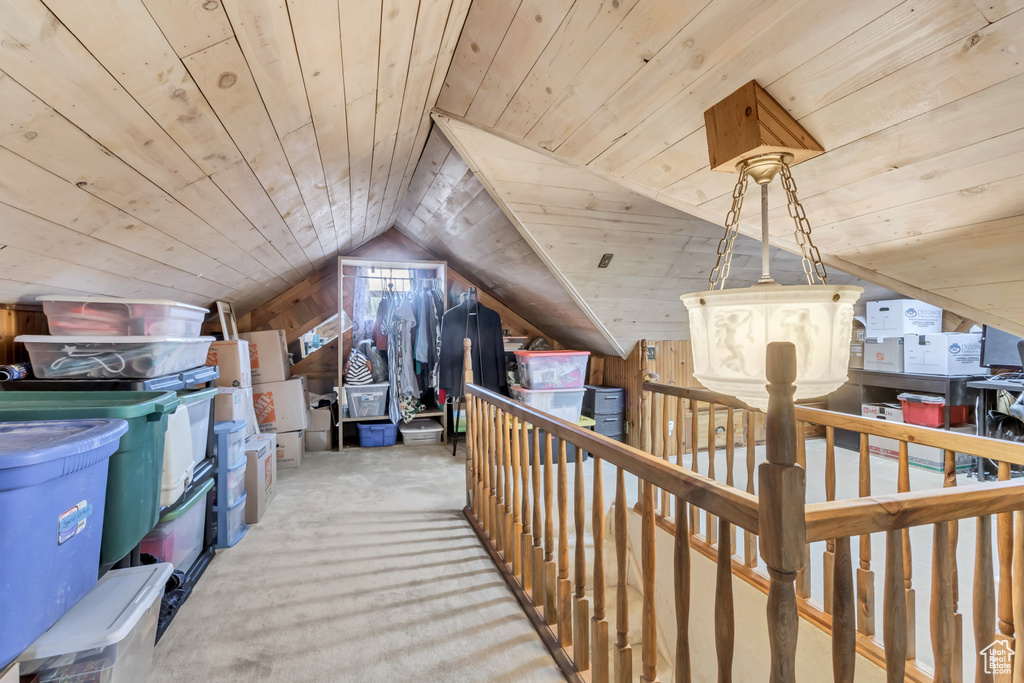 Additional living space with wooden walls, wood ceiling, lofted ceiling, and light carpet
