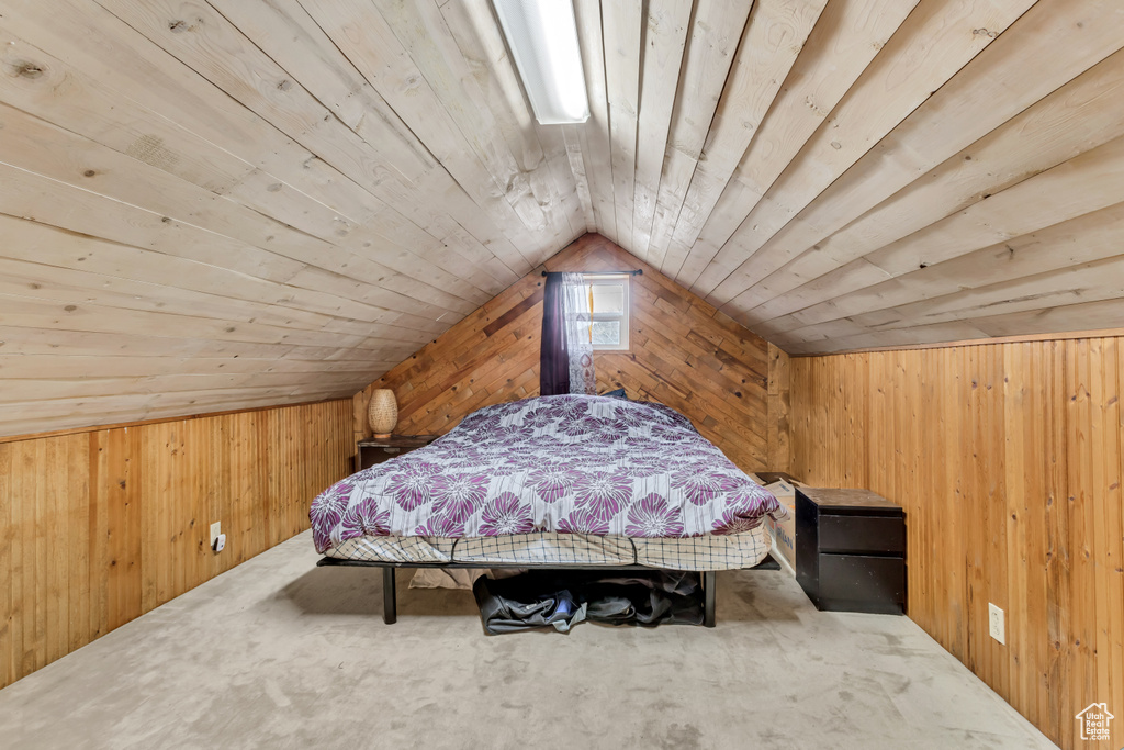 Bedroom featuring wood ceiling, wood walls, and carpet