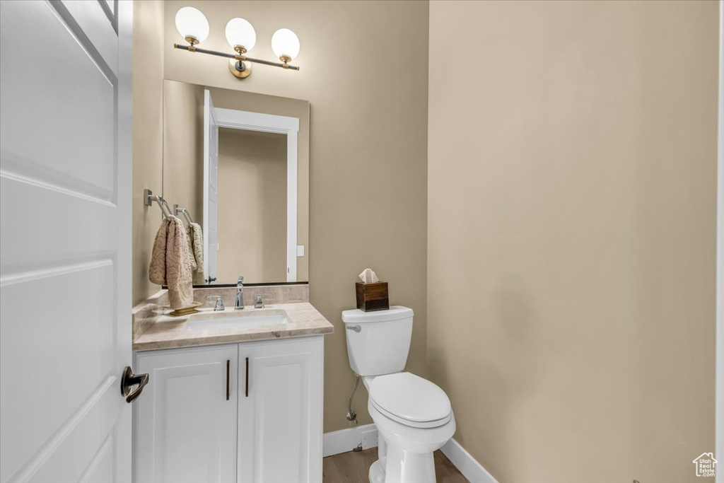 Bathroom with vanity, wood-type flooring, and toilet
