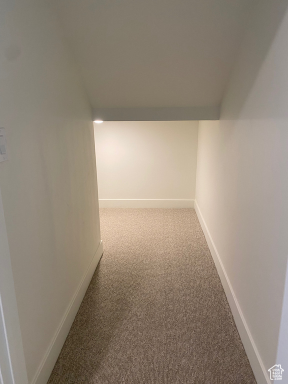 Hallway featuring light colored carpet