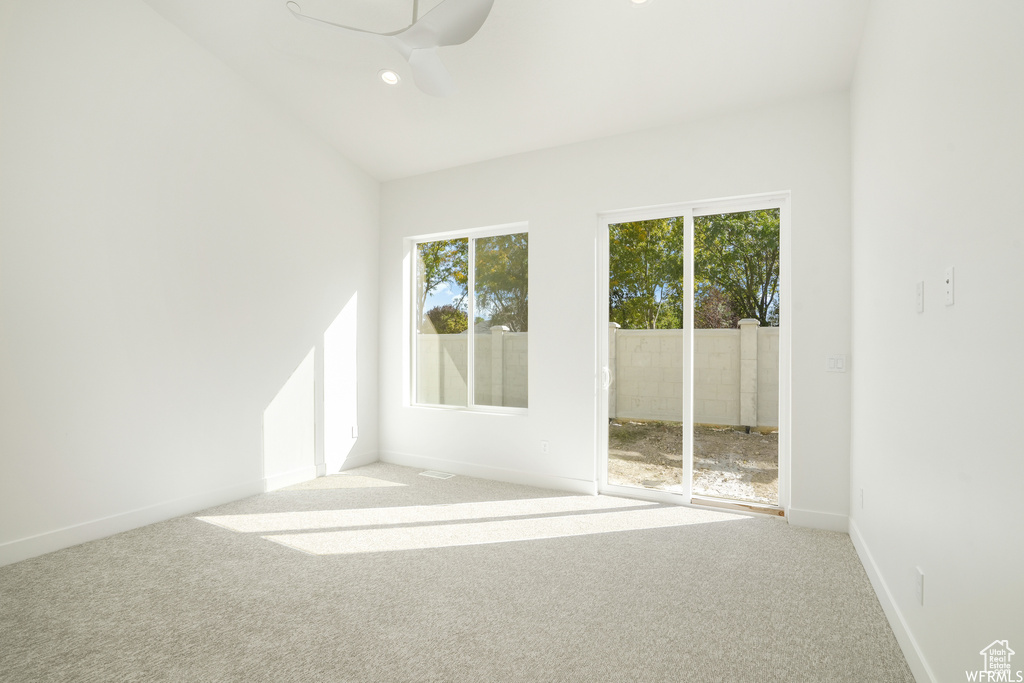 Carpeted spare room with vaulted ceiling