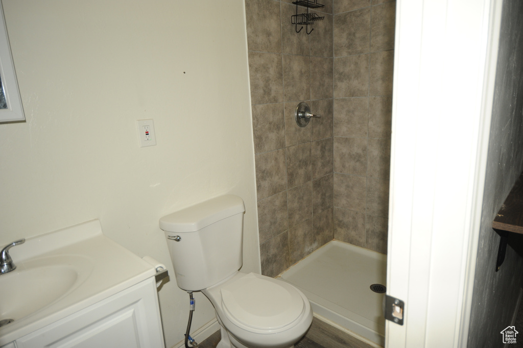 Bathroom with toilet, vanity, and tiled shower