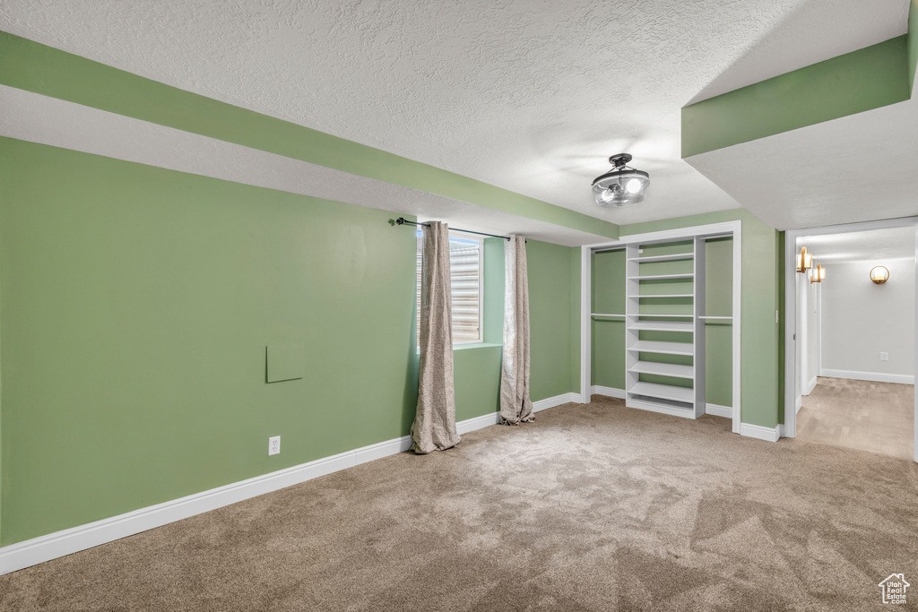 Spare room with a textured ceiling and light carpet