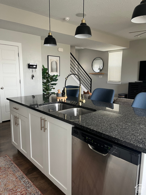 Kitchen featuring white cabinets, dark stone counters, dishwasher, and dark hardwood / wood-style floors